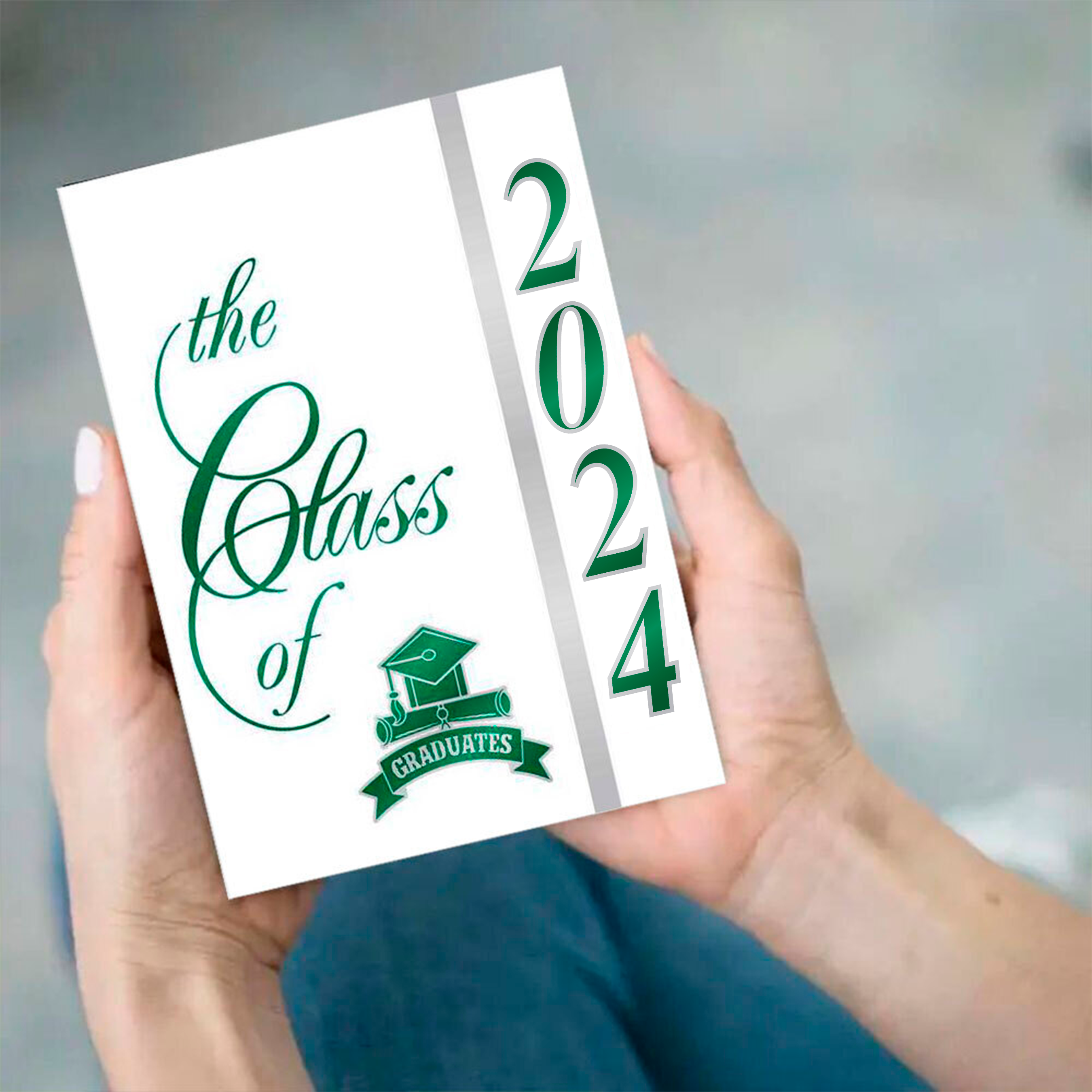 Hands holding a Class of 2021 graduation announcement with green foil.