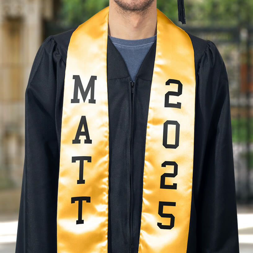 A graduate in a black graduation gown wearing a yellow stole with FlexStyle® text.